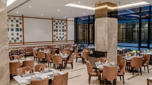 A bright and inviting dining space in Ajmer featuring cosy seating arrangements and a well-lit atmosphere to enjoy meals - Sarovar Portico, Ajmer