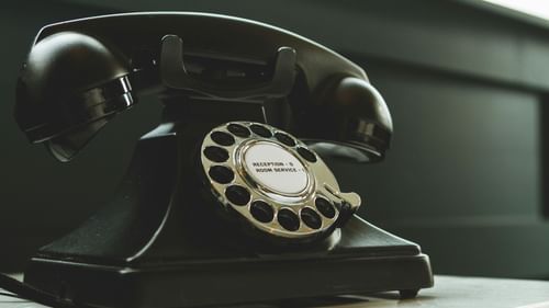A vintage telephone placed on a counter.