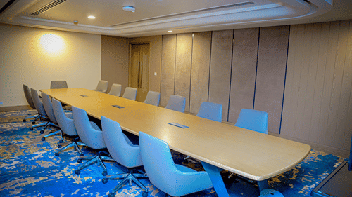 A meeting room with carpeted floors, a long table, and ergonomic chairs - Serene Sarovar Premiere Hargeisa