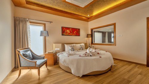 A round king bed with towel doves inside Honeymoon cottage at Shyama Sarovar Portico Orai