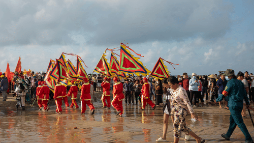 People walking around on the beach with various costumes.