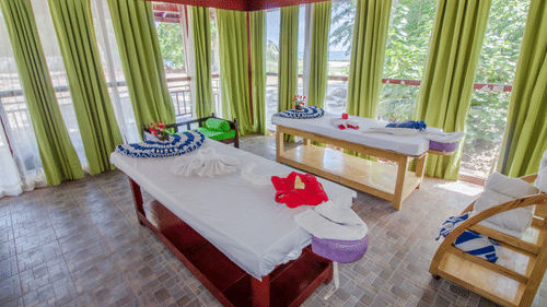 Massage table inside Neil Ocean Spa with curtains covering the floor to ceiling glass - Symphony Summer Sand Beach Resort And Spa, Neil island