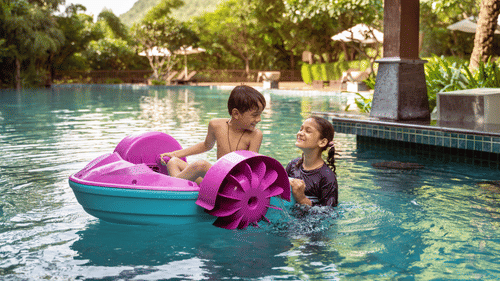 two kids on a pedalled boat in the swimming pool - The Ananta Udaipur