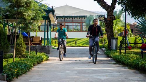 People cycling on a path through a garden