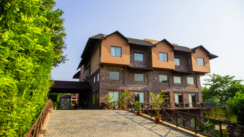 Resort facade with a pathway leading to the building and greenery on both sides - The Baagh Ananta Elite, Ranthambore - Luxury Resort in Ranthambore.