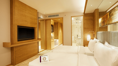 Side view of Premier Rooms featuring a wall-mounted TV and a bedside light in the corner at The Residency Towers Chennai