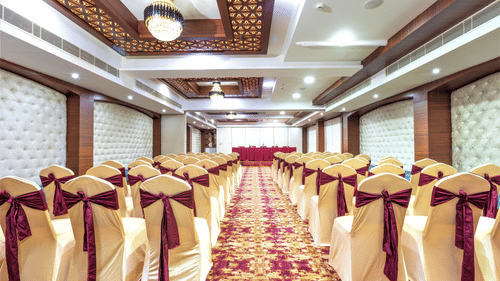 A spacious hall with decorated chairs - The Saibaba Hotel