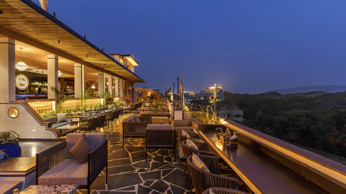 A night view of the terrace with ambient lighting, comfortable lounge areas, and a serene atmosphere.