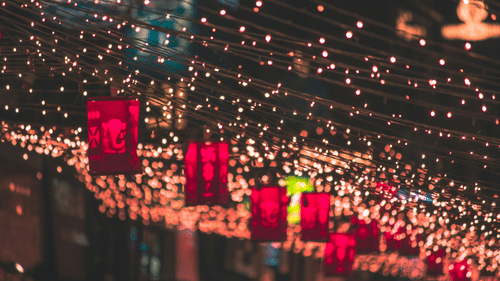 A street market with many lights hanging from the roof during a celebration