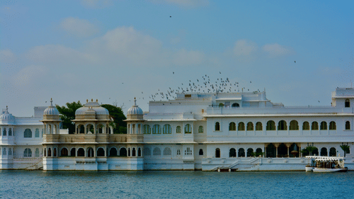 An overview of Lake Palace in Lake Pichola with blue sky in the background.