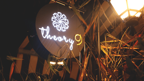 Theory9 bandra's signage in view during the night with the lights on.