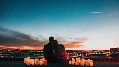 couple watching city lights from a hill
