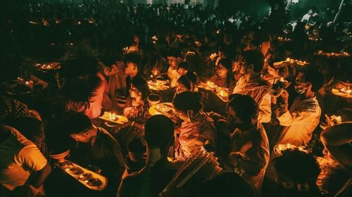 Large crowd gathered at night, illuminated by warm orange lighting.