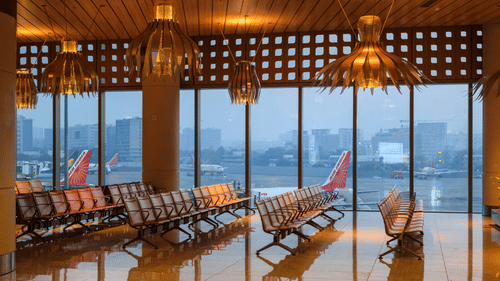 the waiting area inside mumbai airport with lights shining down on the chairs below