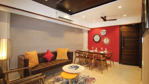living room with wooden furnishings and cosy sofas at theory9 khar