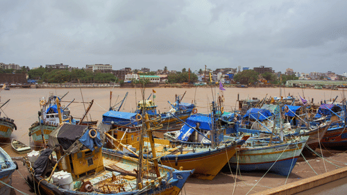 Traditional fishing boats docked at Daman Jetty along the riverfront, showcasing the area's active maritime and fishing culture