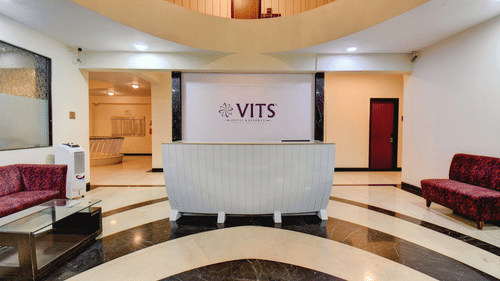 Grand hotel lobby with reception desk and stylish seating at VITS Lonavala.