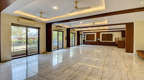 Spacious event hall with modern interiors and large windows at VITS Lonavala.