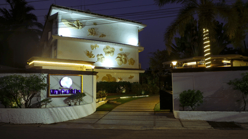facade of White pearl suites by rosetum in the night with the lights on.