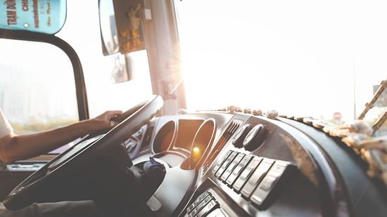 a close up shot of a dashboard of a bus with a person driving it