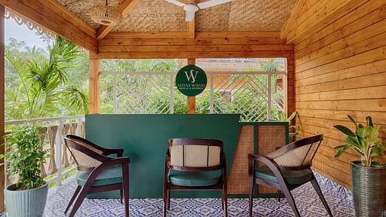 Relaxing resort balcony with wicker chairs, overlooking tropical gardens Aralea Beach Resort by Stone Wood, Morjim