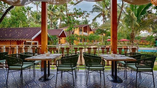 Another angle of the dining area with a focus on the patterned tile floor and the view of the tropical resort setting Aralea Beach Resort by Stone Wood, Morjim