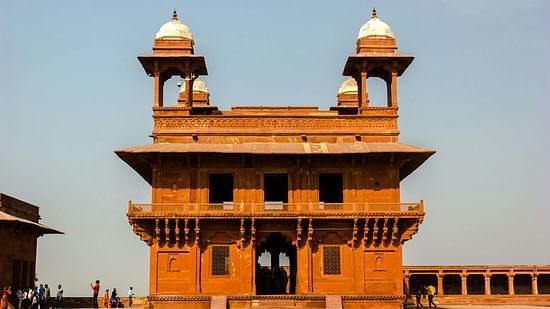 Two-story red sandstone building with domed towers.