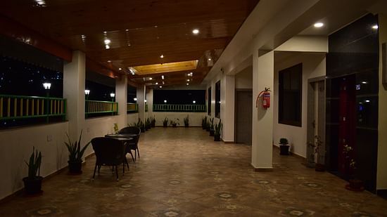 a terrace area with a teapoy and two chairs that offers panoramic mountain view - Hotel Montana Vyoo