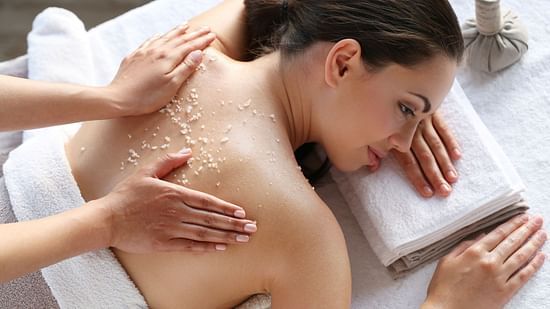 A woman in a massage bed undergoing back scrub