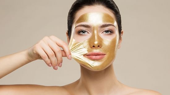 A model peeling off a gold face mask - Best Facial in Raipur