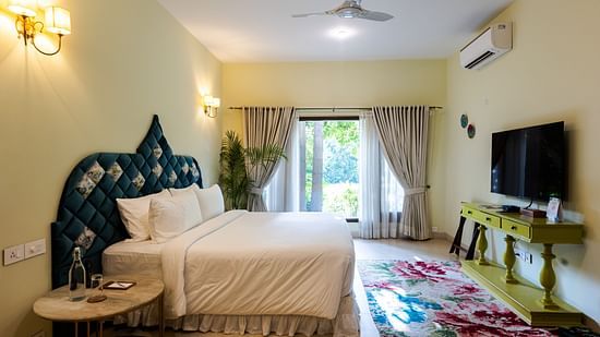 An overview of the Kingfisher Villa with a double bed and side tables - Karma Lakelands.