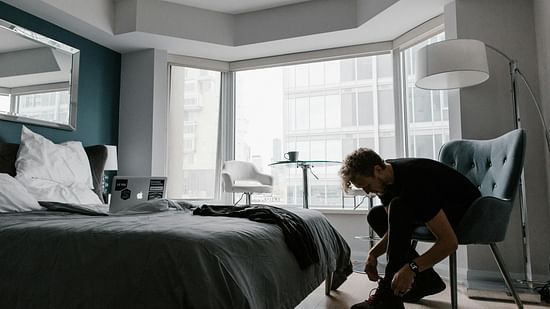 Picture of a man  wearing the shoes while resting on a chair