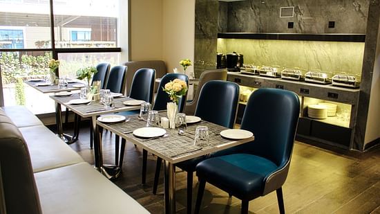 Dining area with buffet table behind at Maxxvalue Hotel MIDC,  Mumbai