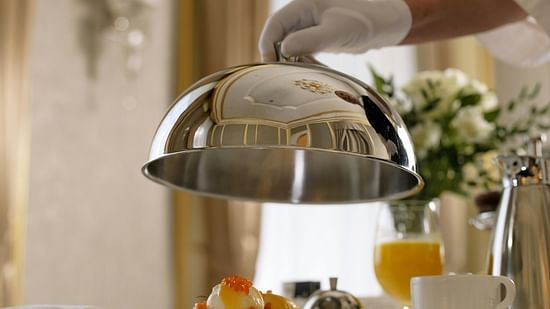 a person lifting a covering from food