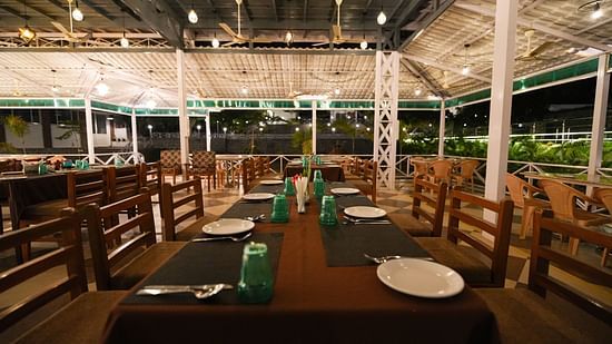 Picture featuring the restaurant, with dining tables arranged and brightly lit.
