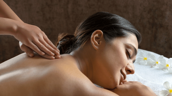 A side view of a woman getting a relaxing massage at a spa.
