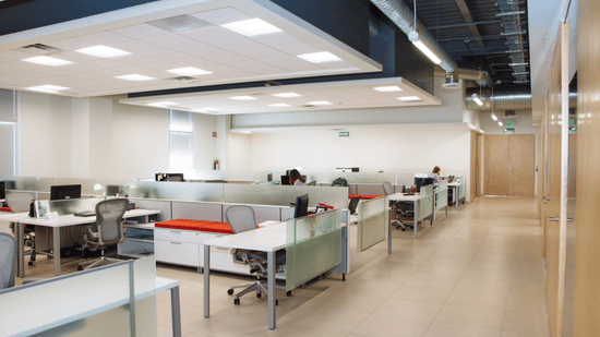 Contemporary office workspace with desks, chairs, and glass walls