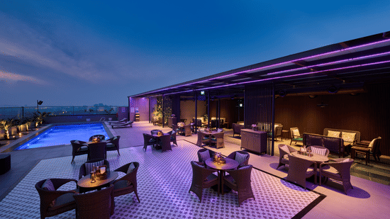Rooftop lounge at Riviera Sarovar Portico, Pathankot with evening lighting, relaxed seating and a lively setting for drinks and conversations.