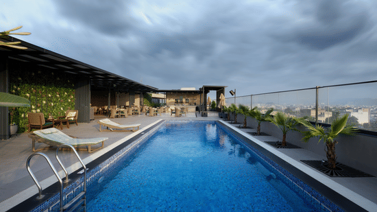 Rooftop swimming pool at Riviera Sarovar Portico, Pathankot surrounded by loungers and open skies, offering a refreshing leisure experience for guests.