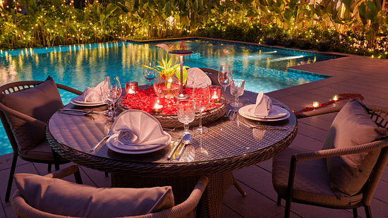 dining setup beside the swimming pool, adorned with glowing candles for an intimate evening at The Dukes Retreat  
