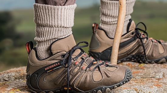 men-s-brown-and-gray-merrell-hiking-shoes-holding-stick-40383
