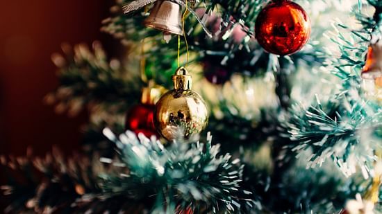 a close up shot of a christmas tree that is decked with christmas ornaments