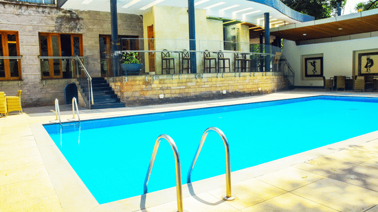 Swimming pool with ladder and hotel building view at The Zehneria, Nairobi