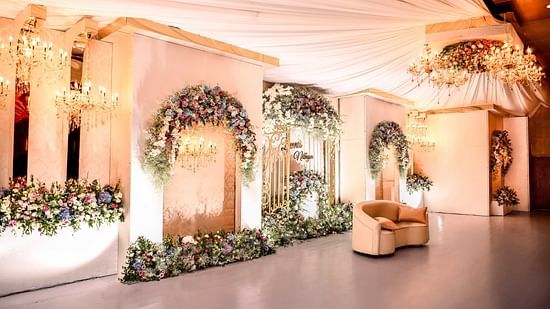 Hall at Uday Palace Convention Centre decorated with fancy clothes and flowers behind a seater
