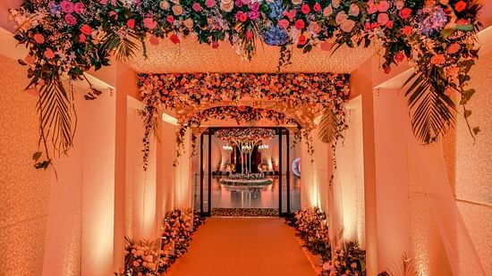 Entrance to the hall of Uday Palace Convention Centre with red carpet on the floor and floral decoration on both sides as well as on the ceiling