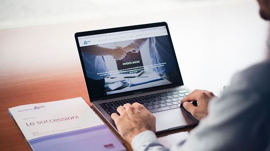 a man using a laptop for business purpose with a file next to him