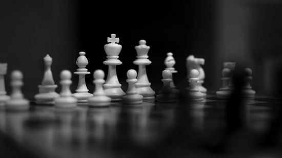 white and black close up image of a chess board with chess pieces