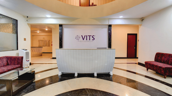 Grand hotel lobby with reception desk and stylish seating at VITS Lonavala.