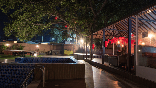 The pool and poolside area pictured at night - Wedlock Greens Hotel Resorts Dhanbad
