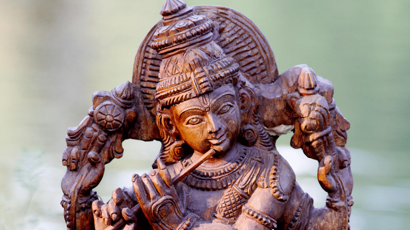 An intricate statue of lord Krishna playing a flute.
